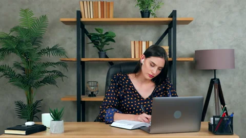 Female student write in notebook performs practical task thinks solution problem Stock Footage 140976945