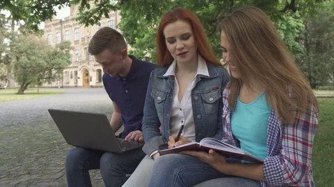 Female student writes in her exercise book on campus Stock Footage 79782645