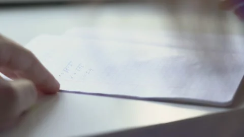 Female student with yellow nails solves math example in paper notebook Stock Footage 190011280