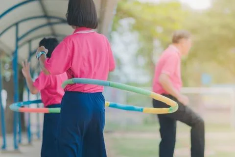 Female students doing exercise with a hula-hoop for a good healt Stock Photos