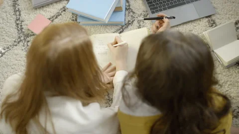 Female students doing math homework together, lying on carpet, solving problems Stock Footage 152035825