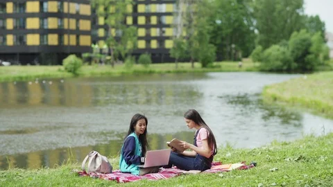 Female students doing project together in nature Stock Footage 112321158