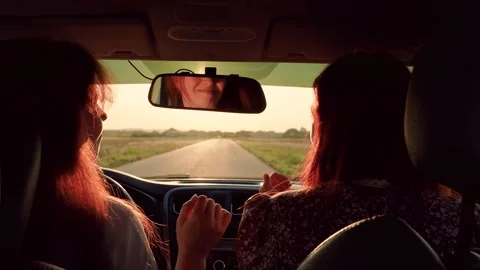Female students driving in car listening to musical song on way sing and dance Stock Footage 306494853
