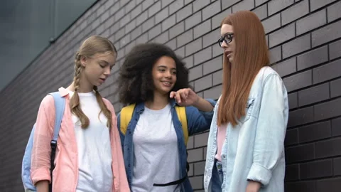 Female students pushing with elbow scared schoolgirl, college bullying backyard Stock Footage 111828323