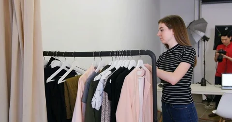 Female stylish selecting apparel from clothes rack Stock Footage