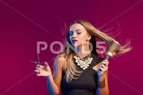 Female stylist standing with hairdresser's accessories Stock Photos
