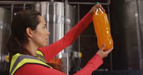Female supervisor checking juice in bottle Stock Footage