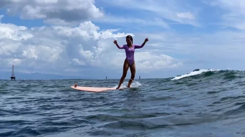 Female Surfer Skillfully Balancing On Small Water Waves Capturing Joy Vidéo 329279407
