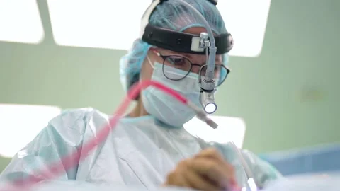 A female surgeon performs a delicate operation using a medical surgical 動画素材 181795558