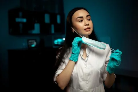 Female surgeon posing while removing face mask Stock-Fotos