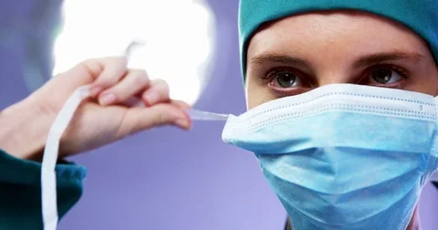 Female surgeon wearing surgical mask in operating room Stock Footage
