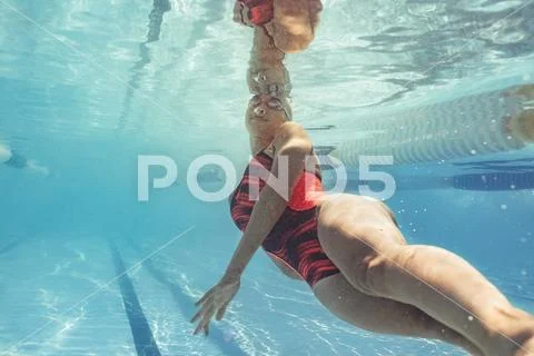 Female swimmer in action inside pool Stock Photos