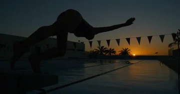 A female swimmer does a slow motion racing dive. Video stock 85569650