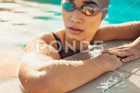 Female swimmer resting after a swim Stock Photos
