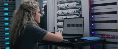 Female System Administrator Analyzing Server Performance Metrics on Laptop Stock Footage 347885234