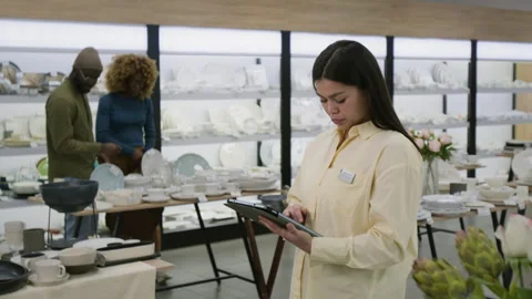 Female Tableware Store Manager Ordering Stock on Tablet in Showroom Stock Footage 321773831