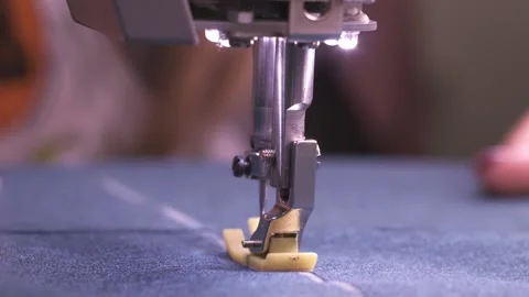 Female tailor hands sewing at automatic sewing machine. Push blue fabric into a Video stock 151140801