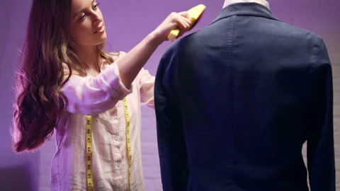 Female tailor preparing dark blue velvet male jacket for customer or fashion Stock Footage 301454813