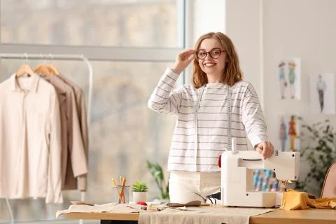 Female tailor with sewing machine at table in atelier Stock Photos