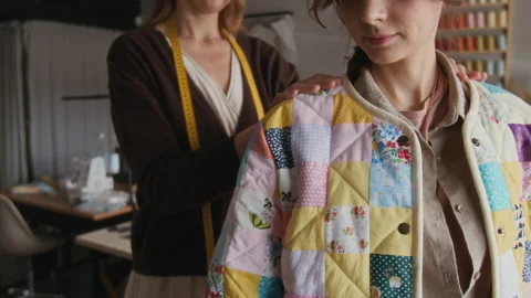 Female Tailor Trying on Patchwork Jacket on Colleague in Studio 스톡 동영상 315769666
