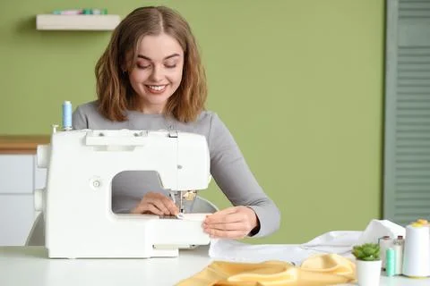 Female tailor using sewing machine at table in atelier Stock Photos
