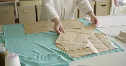Female tailor using sewing patterns while working on creation of sweatshirt Stock-Footage 200955384