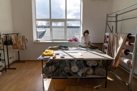 Female tailor work with fabric in studio. Young clothes designer measure cloth Stock Photos
