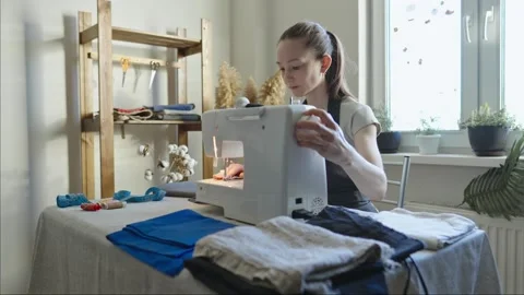 A female tailor is working on a sewing machine stitching fabric Stock Footage 297938328
