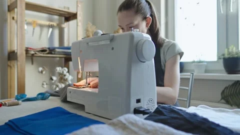A female tailor is working on a sewing machine stitching fabric Stock Footage 297938716