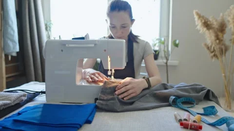 A female tailor is working on a sewing machine stitching fabric Stock Footage 297938956