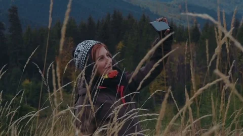 Female taking selfie using her phone in mountains Video stock 82823766