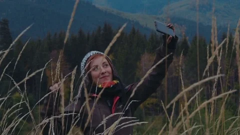 Female taking selfie using her phone in mountains Видео 82823773