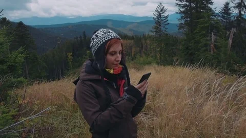 Female taking selfie using her phone in mountains Stock Footage 82823856