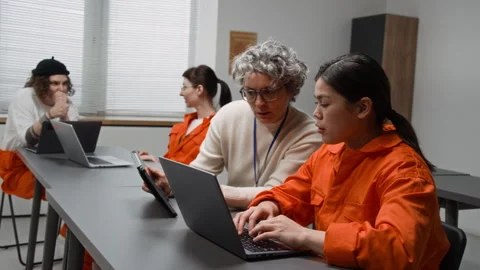 Female Teacher Assisting Inmate Using Laptop in Class Stock Footage 329001759