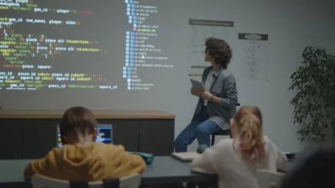 Female Teacher Explaining Code on Screen Projection to Students Stock Footage 244702005