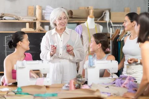 Female teacher explaining pattern structure by chalkboard during sewing course Stock-Fotos
