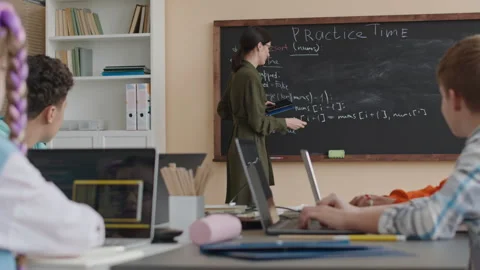 Female Teacher Explaining Program Coding to Preteen Students Stock Footage 248530622