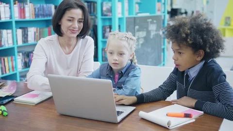 Female teacher explaining students how to study on laptop Stock Footage 108746833