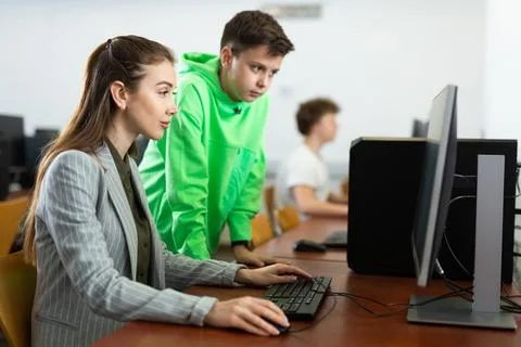 Female teacher explaining task solution to young boy 스톡 사진
