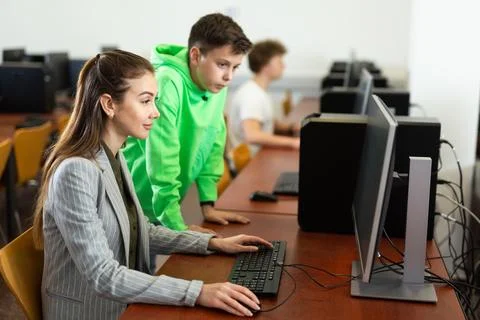 Female teacher explaining task solution to young boy 写真素材