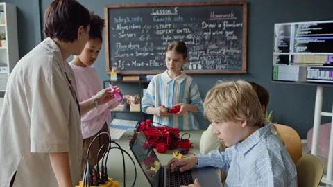 Female Teacher Helping Schoolboy with Coding in Robotics Class Stock Footage 339203337