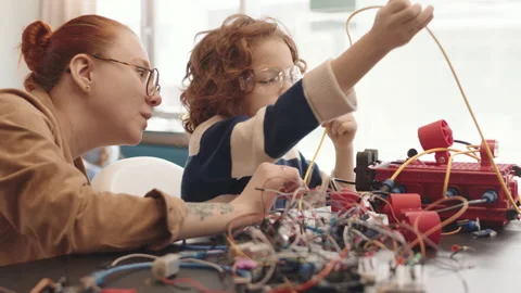 Female Teacher Helping Schoolboy Constructing Robot Video stock 153466729