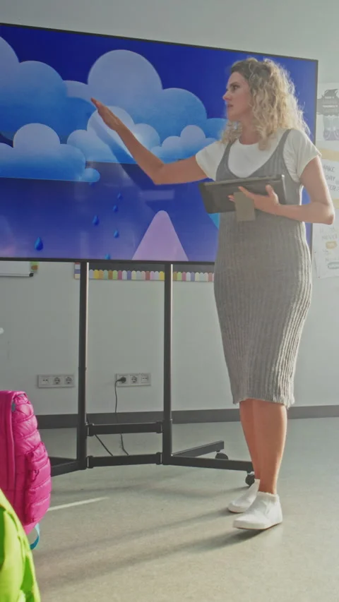 Female Teacher with Tablet Computer Explaining Water Cycles to Kids Using Stock Footage 315535599