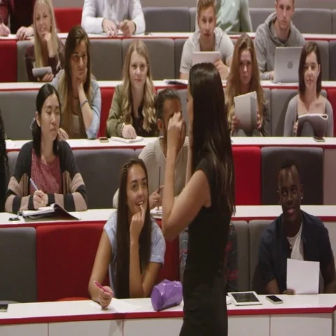 Female teacher talking with students in a lecture theatre, shot on R3D Stock Footage