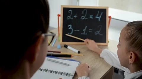 Female teacher teaching kid math using chalkboard. Stock Footage 273566833