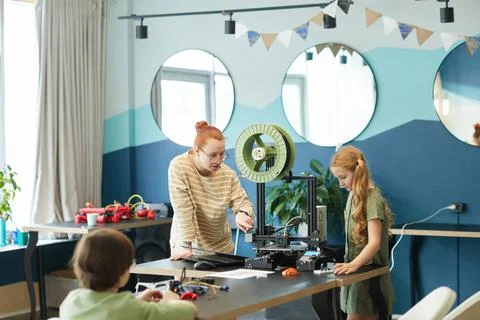 Female Teacher using 3D Printer with Kids in Robotics Class Stock Photos