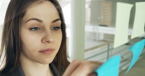 Female team create brainstorming ideas on sticky notes at modern glass office Stock Footage 124796765