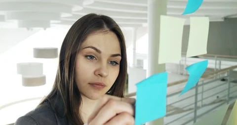 Female team create brainstorming ideas on sticky notes at modern glass office Stock Footage 124925752