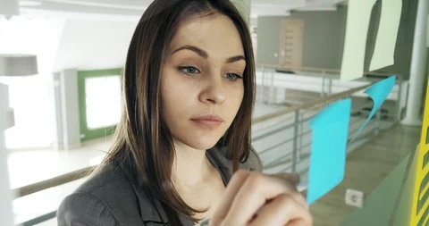Female team create brainstorming ideas on sticky notes at modern glass office Stock-Footage 129572659