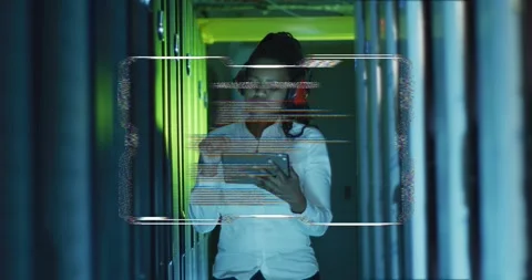 Female tech adjusting headset, tapping tablet and diagnosing server racks with Stock Footage 334312837
